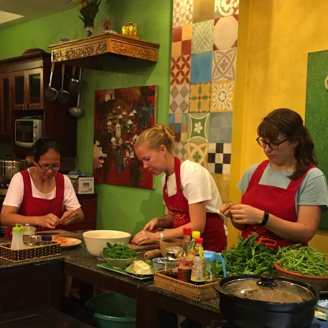 Three tourists learning to cook.